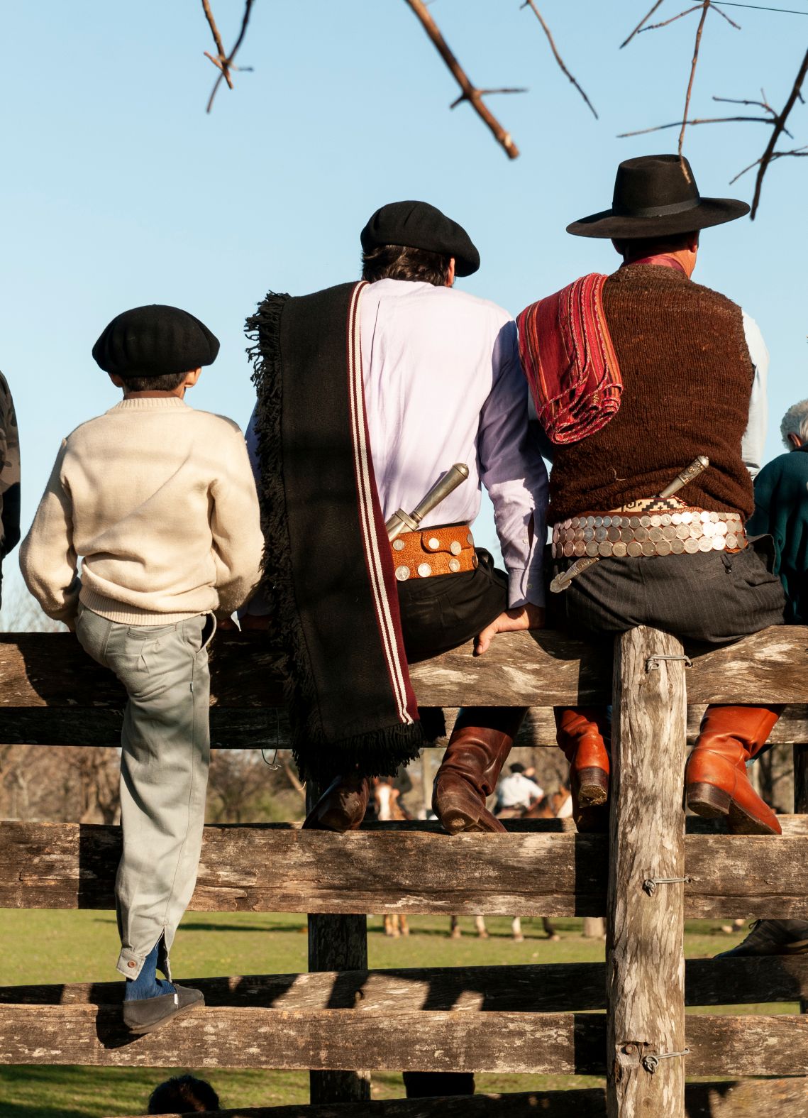 Local gaucho men sat on a fence in Argentina