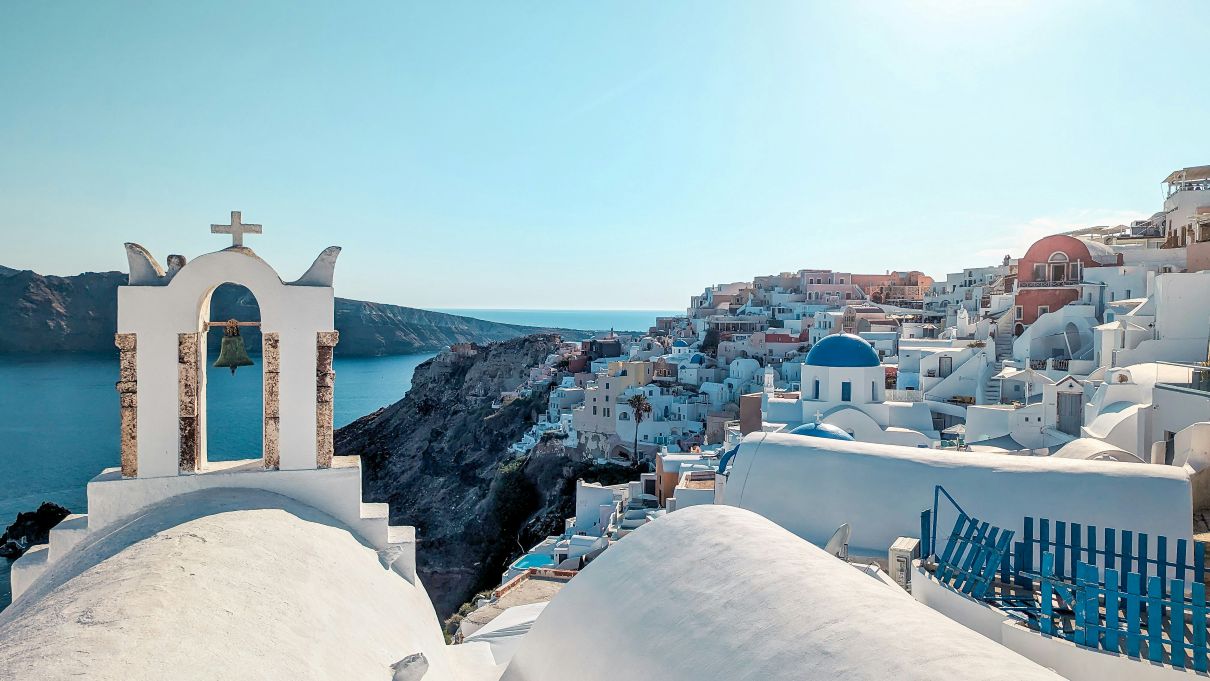 Boats and houses along a cliff on a Greek island