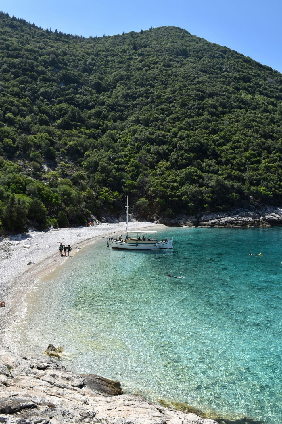 Boat on the shore of an untouched green island in Greece